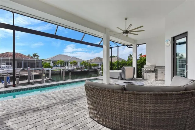 a view of a house with pool and chairs next to a yard