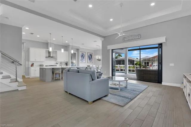 a living room with furniture and a view of kitchen