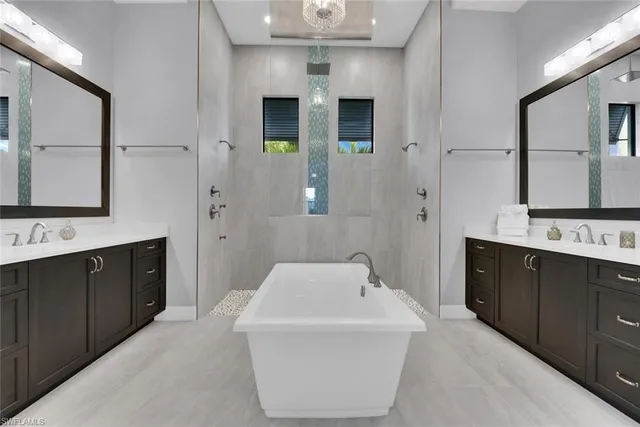 a bathroom with a sink a large mirror and a bathtub