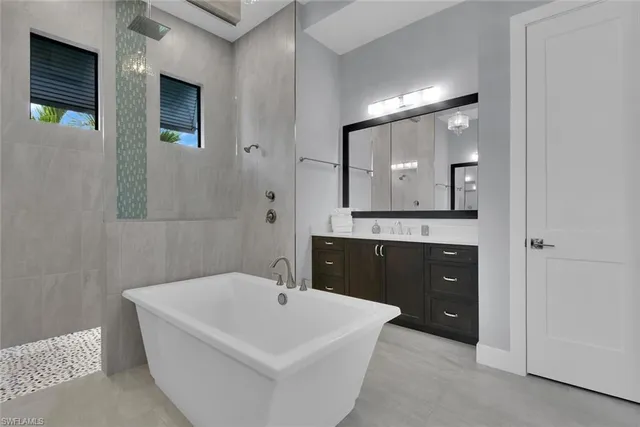 a bathroom with a tub sink and mirror