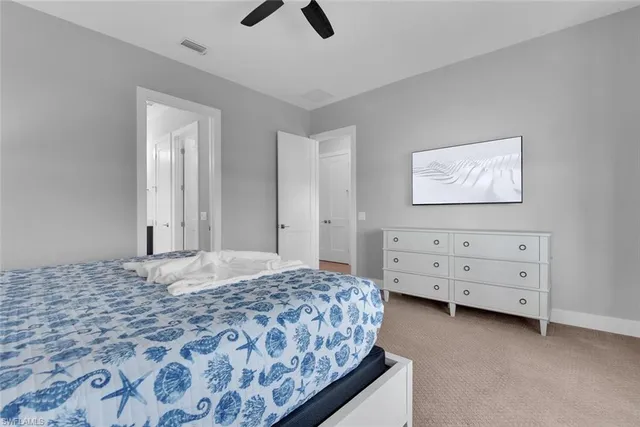 a bathroom with a toilet a double vanity sink and a mirror