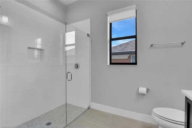 a bathroom with a granite countertop sink a toilet and a mirror