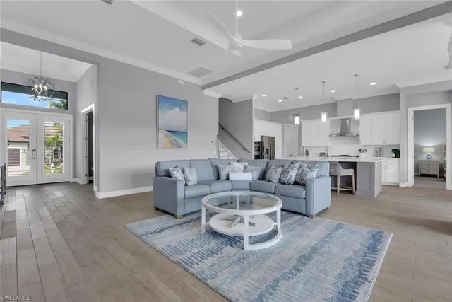 a view of a hallway with wooden floor and a bathroom
