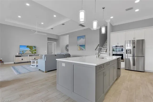 a kitchen with a dining table chairs cabinets wooden floor and appliances
