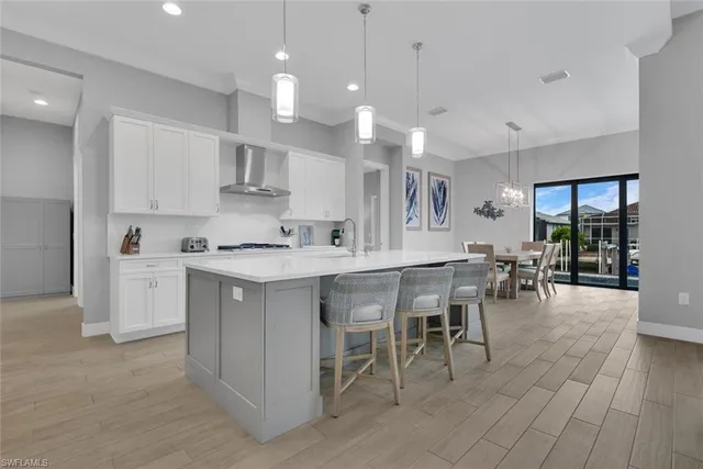 a kitchen with a white cabinets and chairs in it