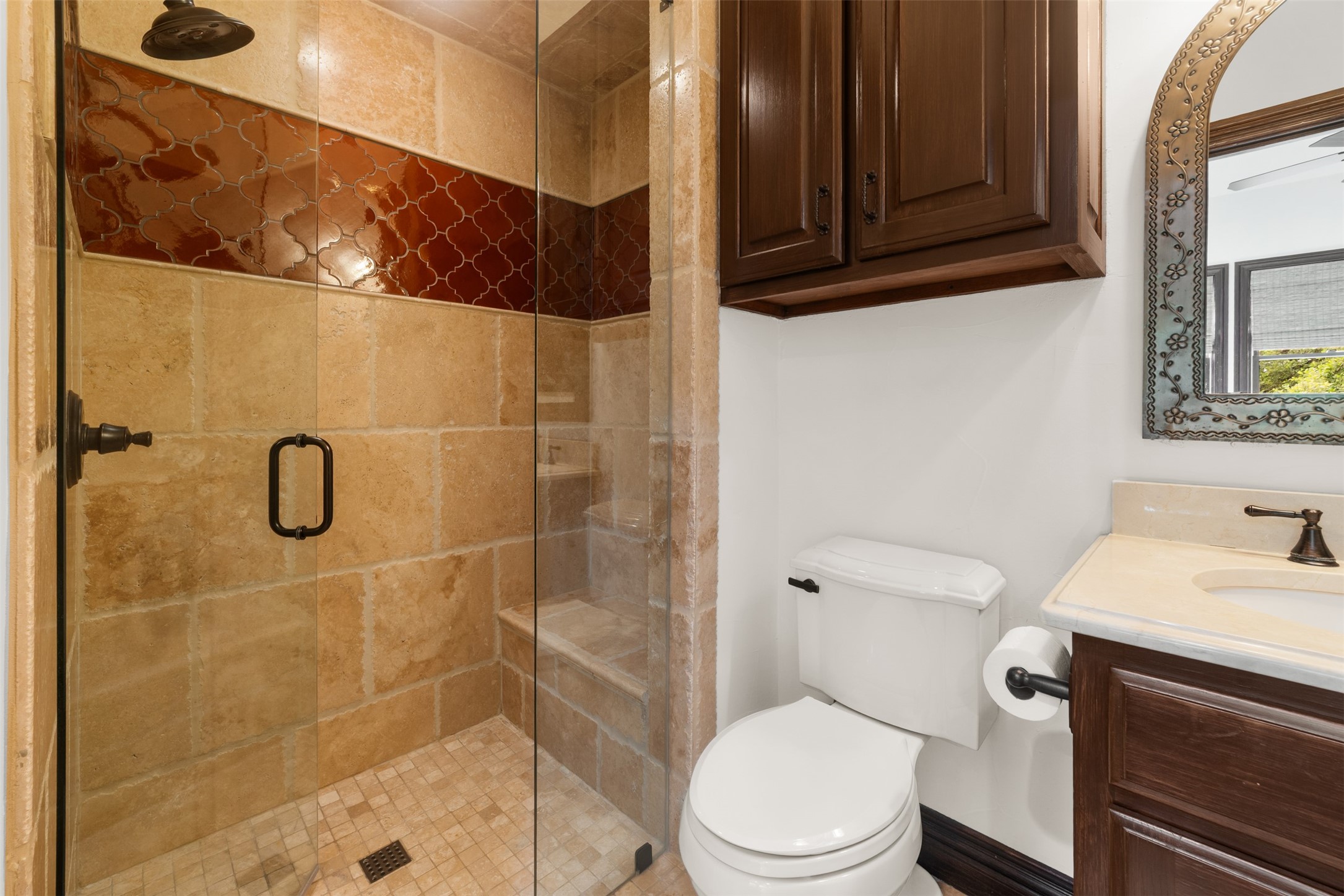 34000 Smithson Valley Road Bulverde, TX 78163 - Photo 14 of 50 Thoughtfully appointed with travertine stone, decorative tile accents, and a glass-enclosed shower. Timeless finishes create a warm and inviting guest bath experience.