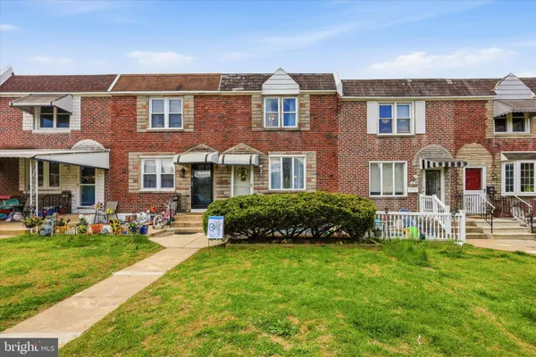 front view of a brick house with a yard