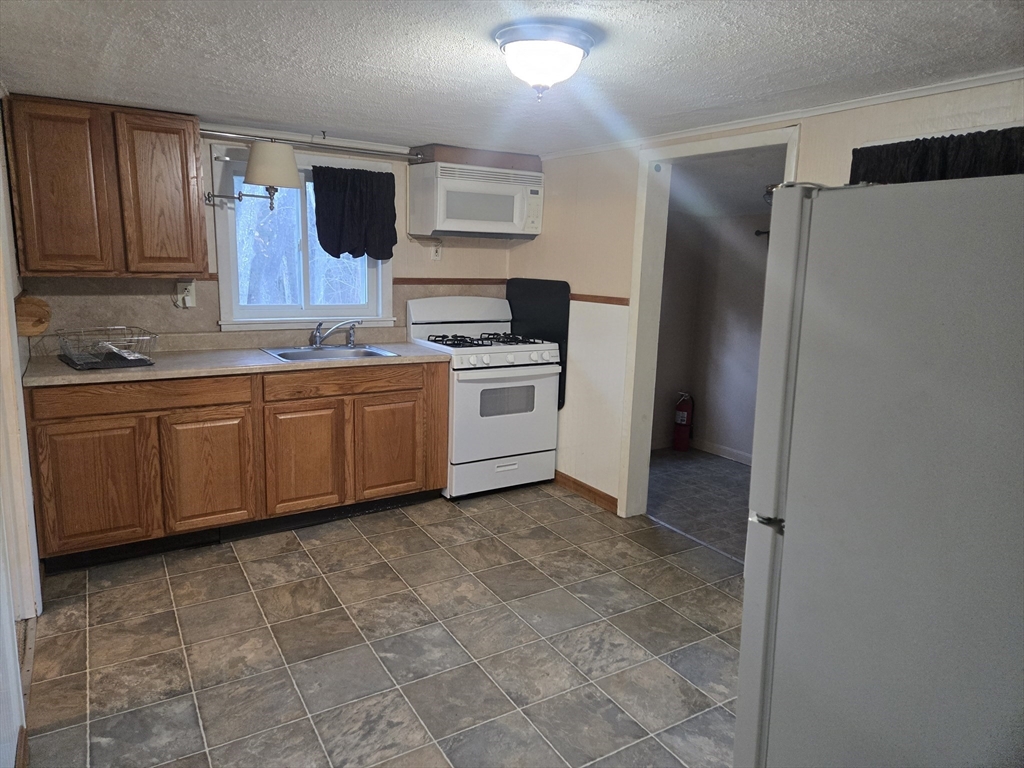 59 Edgehill Road, Unit 2 Taunton, MA 02780 - Photo 2 of 15 a kitchen with stainless steel appliances a sink and a refrigerator
