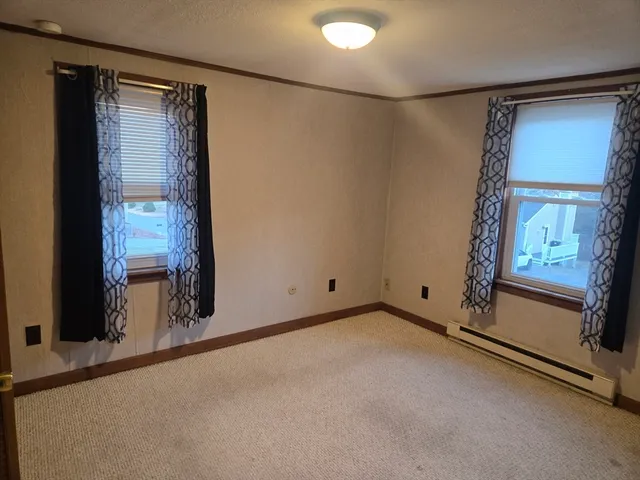 a view of an empty room with a fireplace and a window