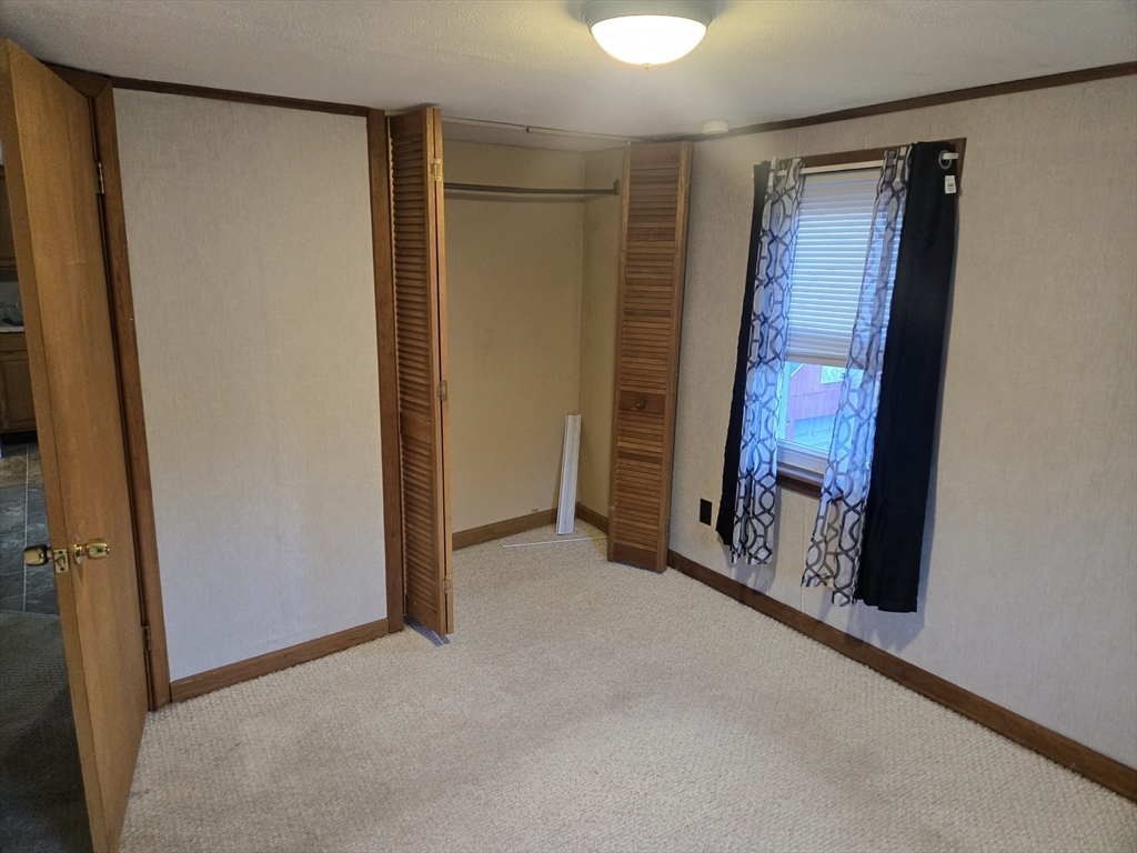 59 Edgehill Road, Unit 2 Taunton, MA 02780 - Photo 5 of 15 a view of an empty room with brick wall