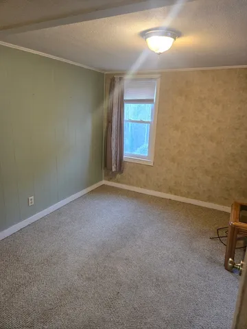 an empty room with a chair and a window