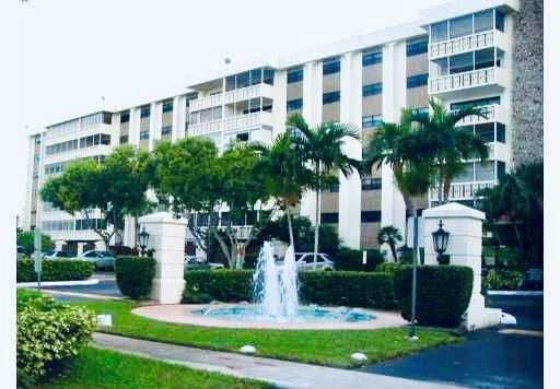 a front view of a building with a garden and plants