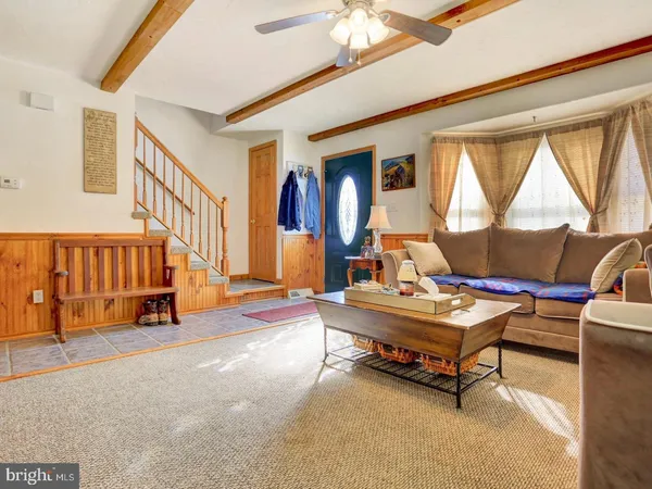 a living room with furniture a table and a large window