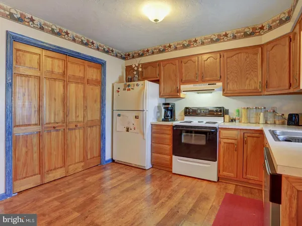 a kitchen with granite countertop a refrigerator and wooden cabinets