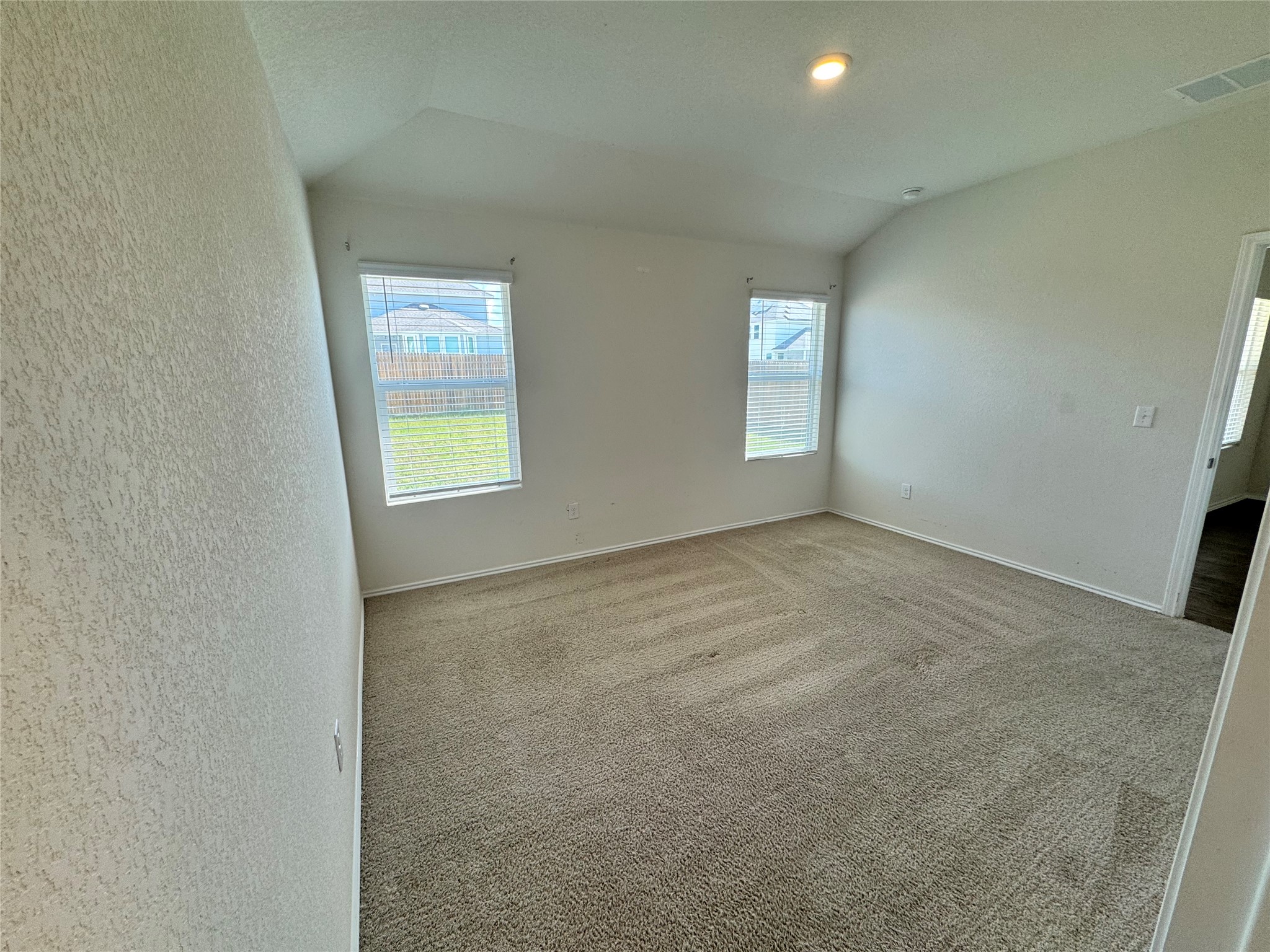 11820 Rush Lane Elgin, TX 78621 - Photo 21 of 31 An airy bedroom with vaulted ceilings and plush carpeting awaits your personal touch.