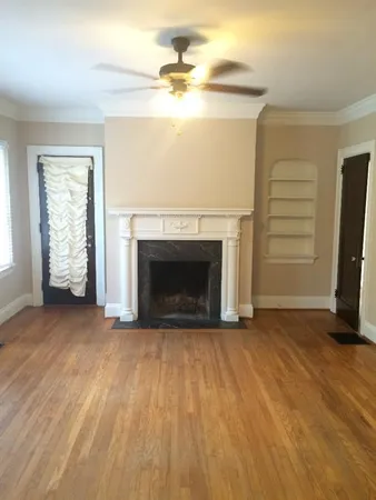 an empty room with windows and a fireplace