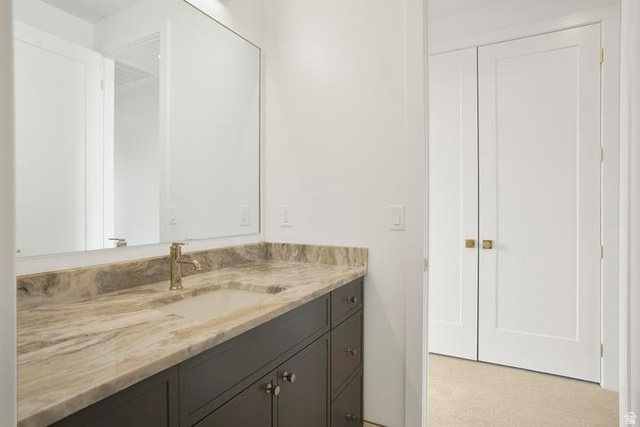 990 Manen Street Washington, UT 84780 - Photo 30 of 43 Bathroom vanity featuring a light-toned stone countertop with an integrated rectangular sink