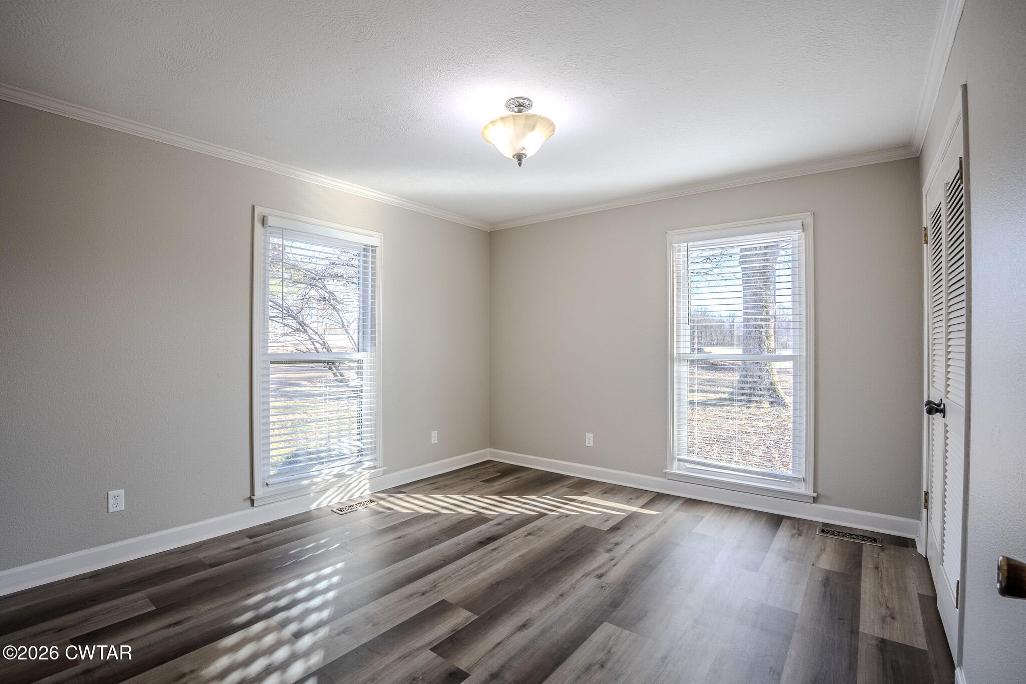 2467 Windrow Road Brownsville, TN 38012 - Photo 19 of 32 an empty room with wooden floor chandelier and windows
