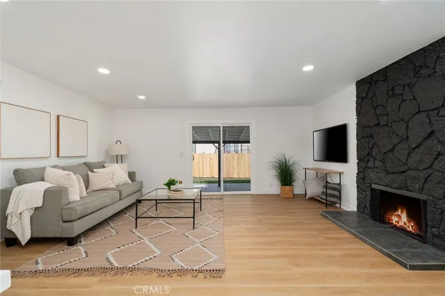 a living room with furniture a flat screen tv and a fireplace