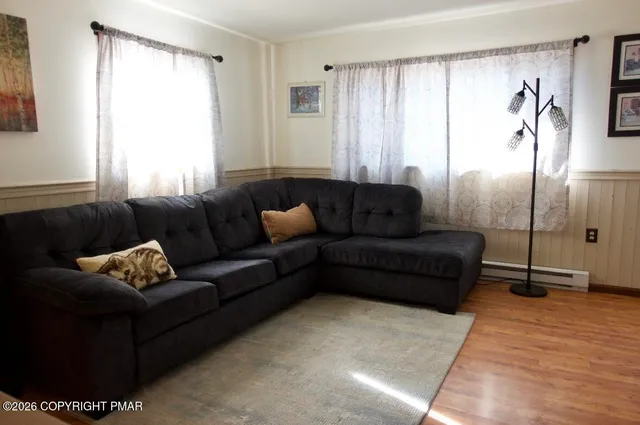 a view of a livingroom with wooden floor and furniture