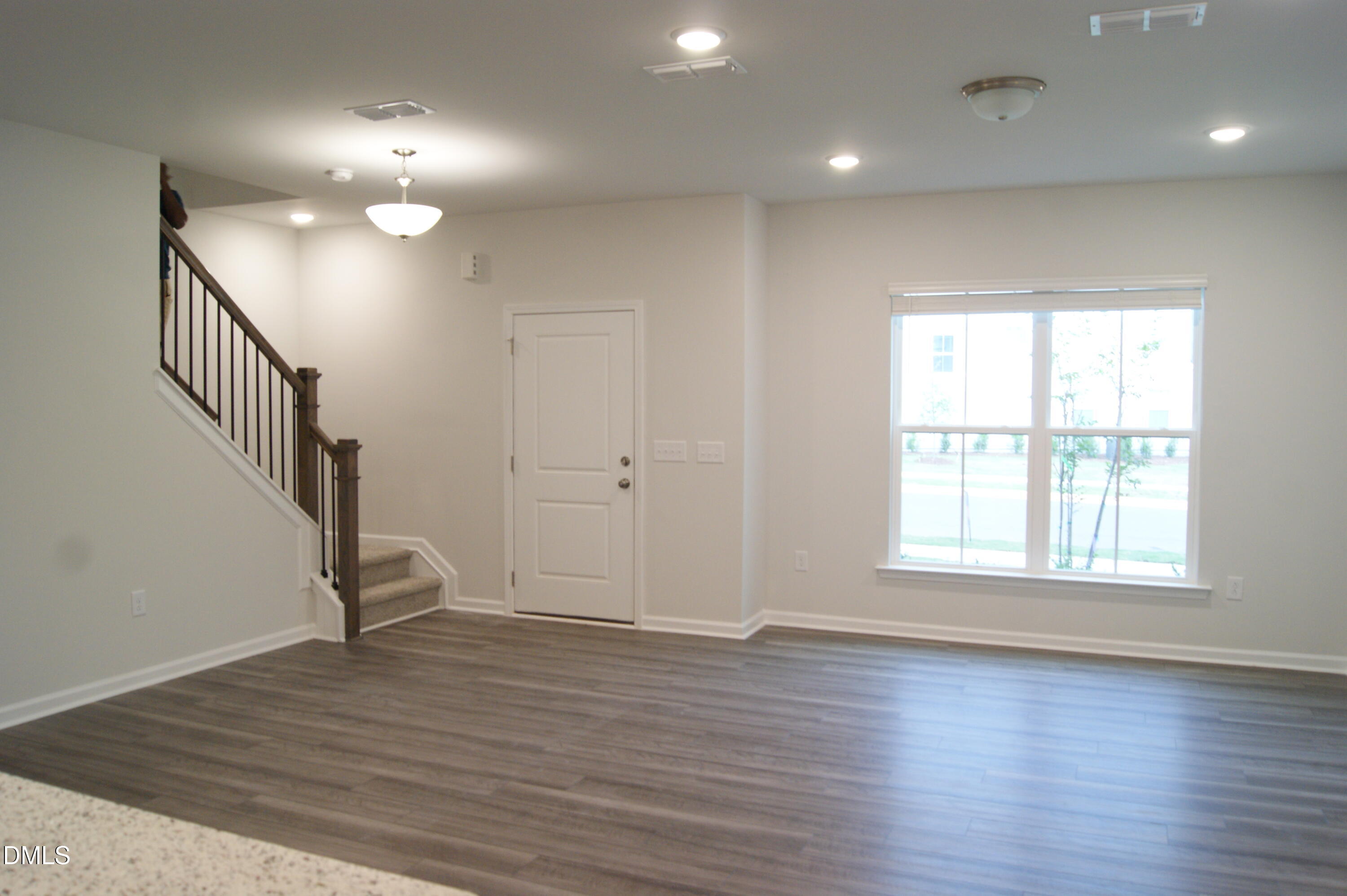 295 Glenmore Gardens Road Raleigh, NC 27603 - Photo 3 of 30 an empty room with wooden floor and windows