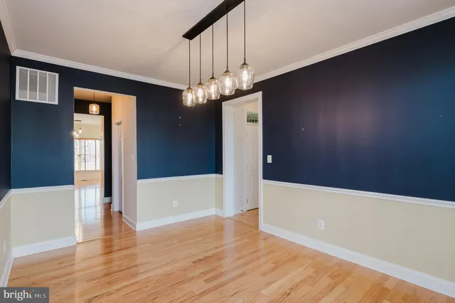 a kitchen with stainless steel appliances granite countertop a stove a sink and white cabinets with wooden floor