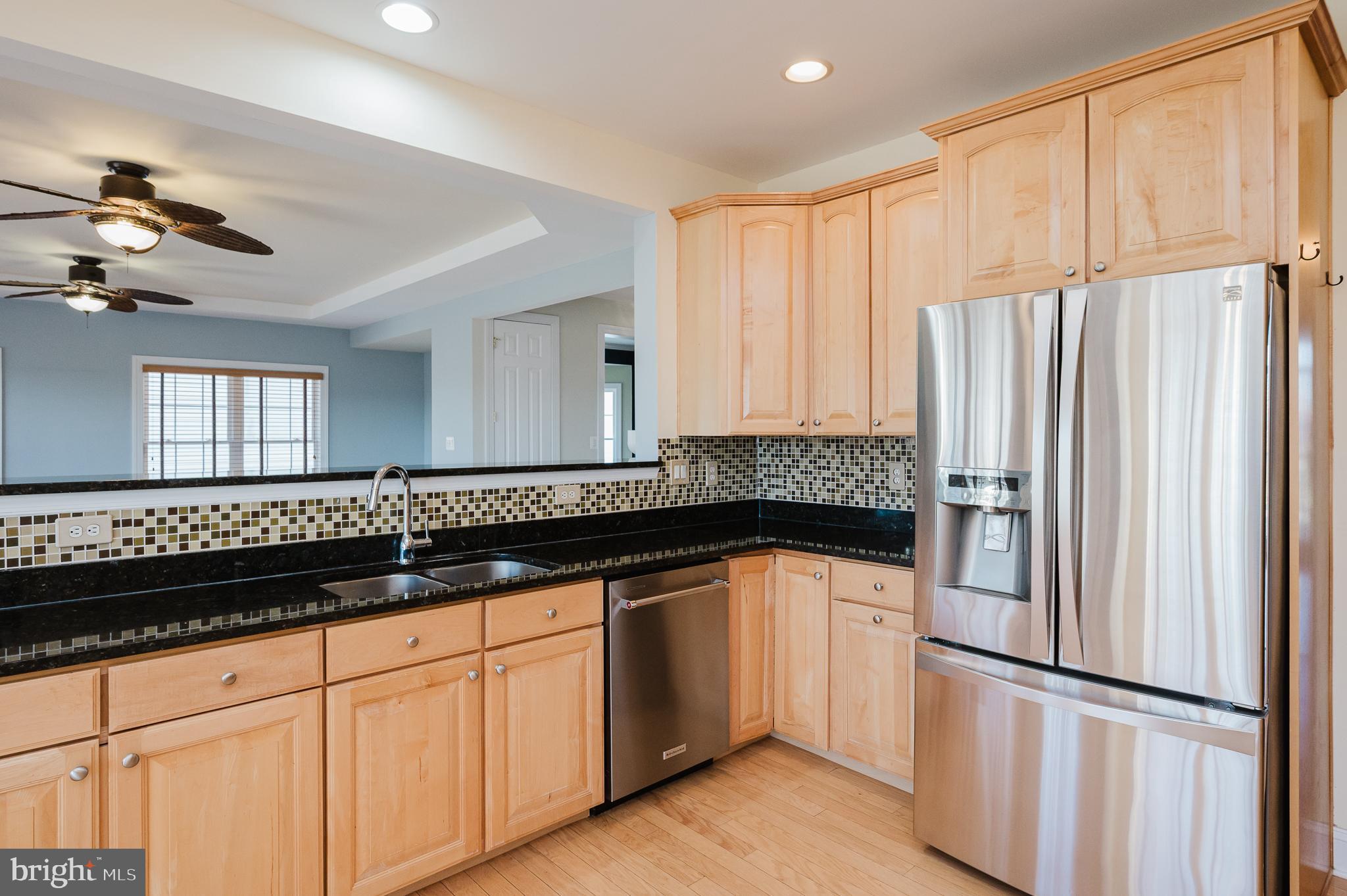 130 Fallston Meadow Court Fallston, MD 21047 - Photo 27 of 80 a kitchen with granite countertop a refrigerator a sink and white cabinets