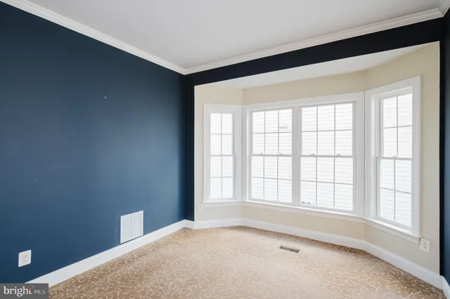 a view of an empty room with wooden floor and a chandelier