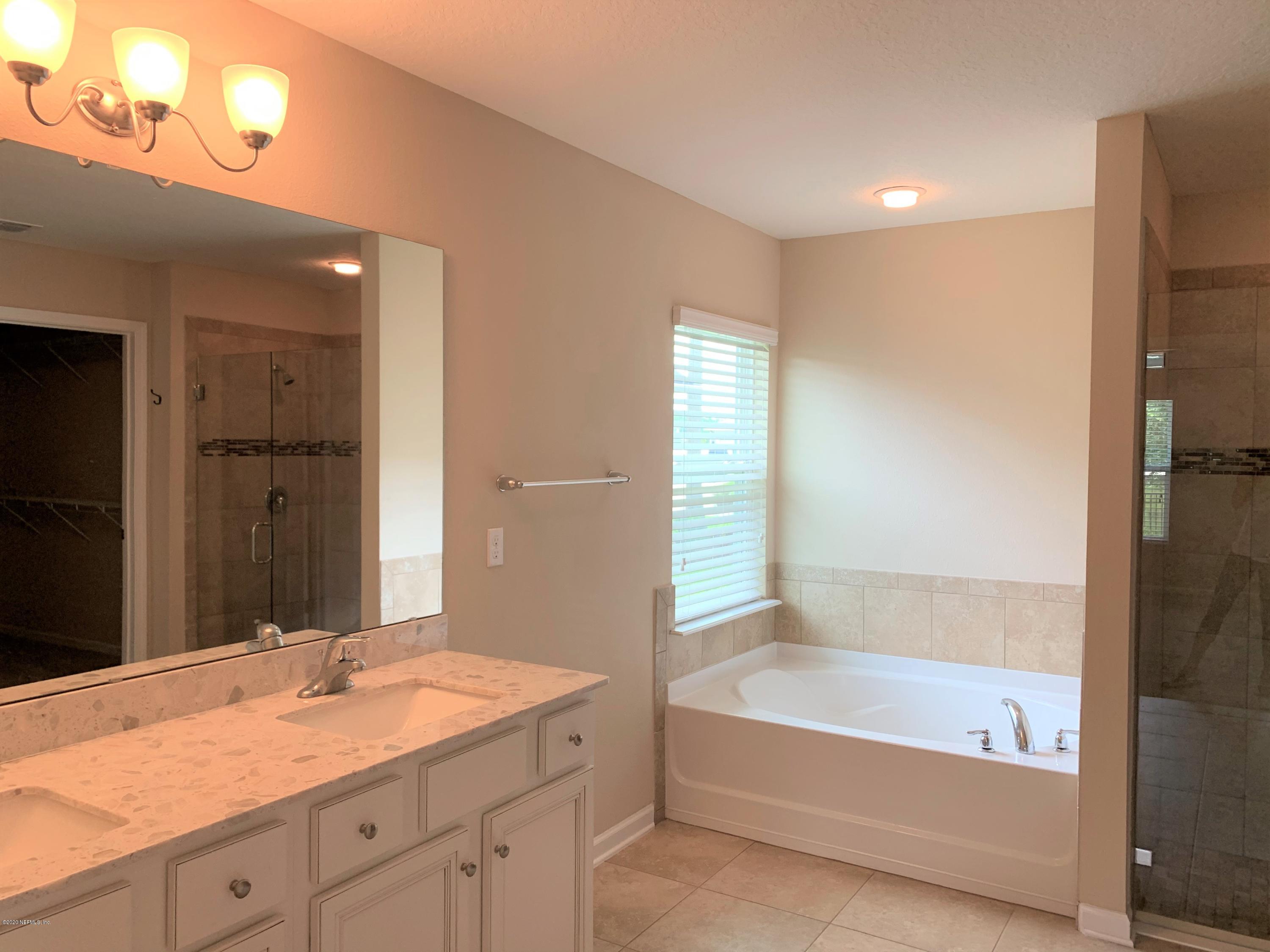 203 Providence Drive St. Augustine, FL 32092 - Photo 10 of 21 a bathroom with a granite countertop sink a mirror and a bathtub