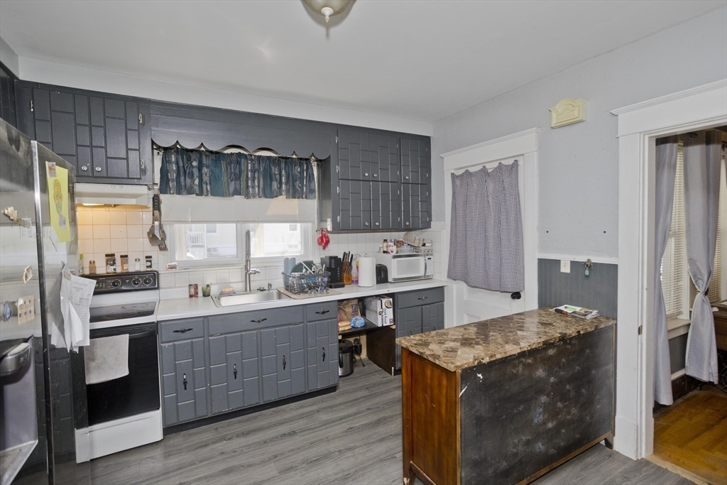 2278-2280 Main Street Three Rivers, MA 01080 - Photo 8 of 37 a kitchen with stainless steel appliances granite countertop a stove a sink dishwasher a refrigerator and white cabinets with wooden floor