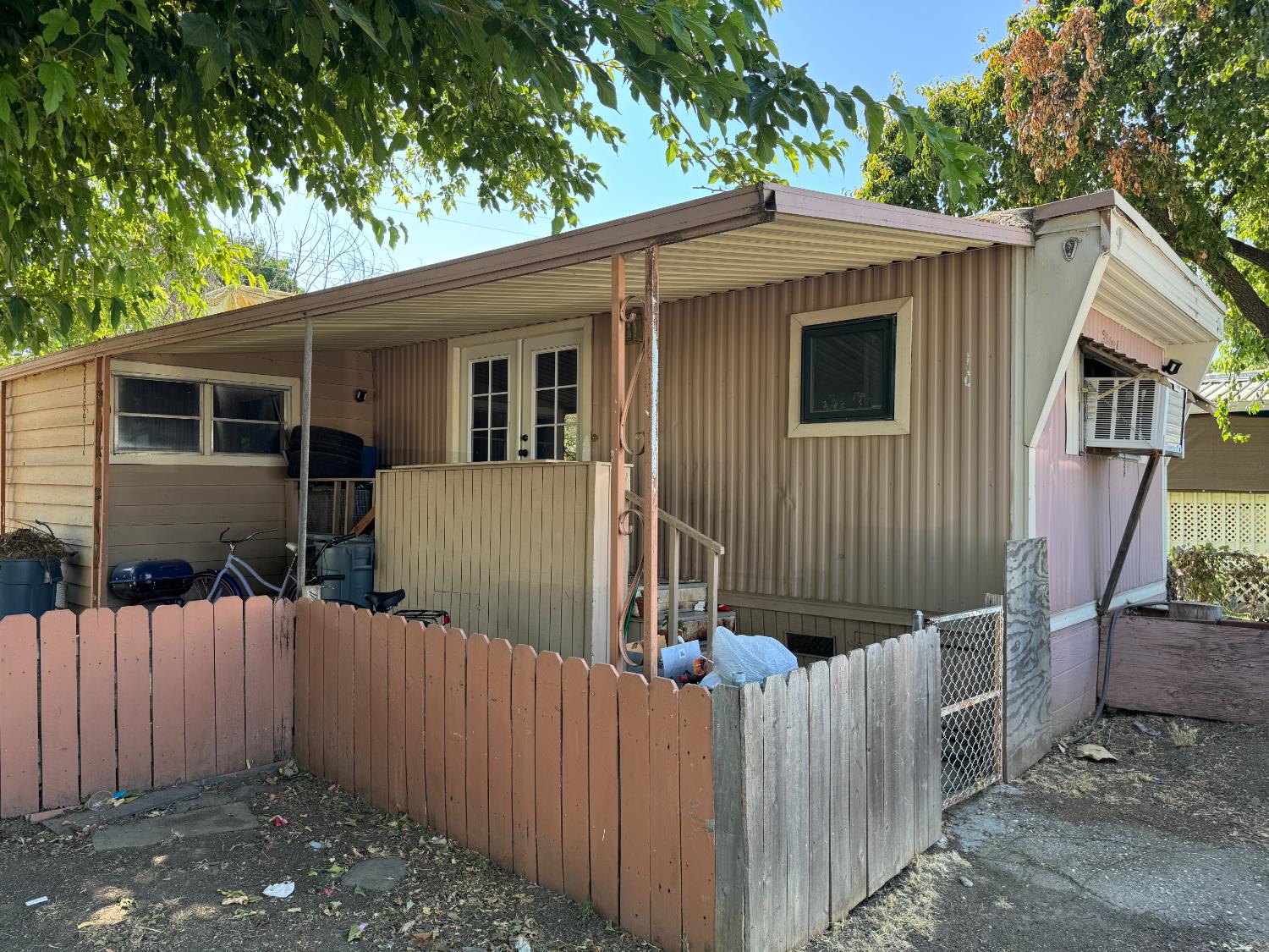 a view of a small house with wooden fence