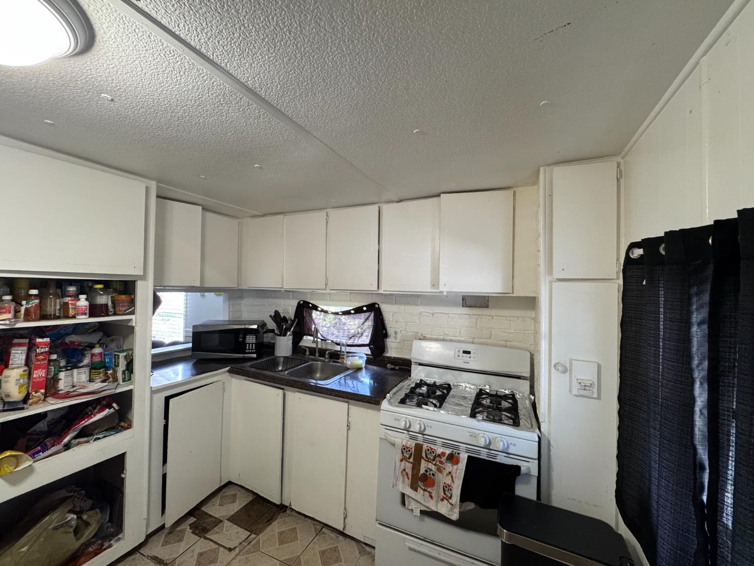 1781 Franklin Road, Unit 36 Yuba City, CA 95993 - Photo 6 of 12 a kitchen with a refrigerator a stove and a bookshelf