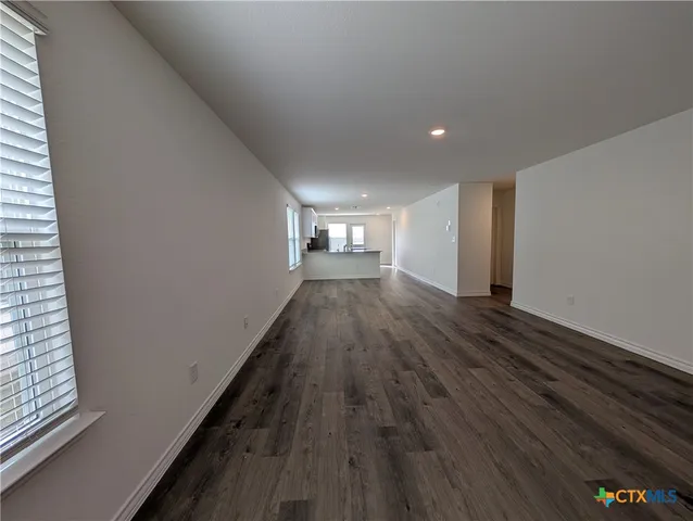 a view of empty room with wooden floor and fireplace