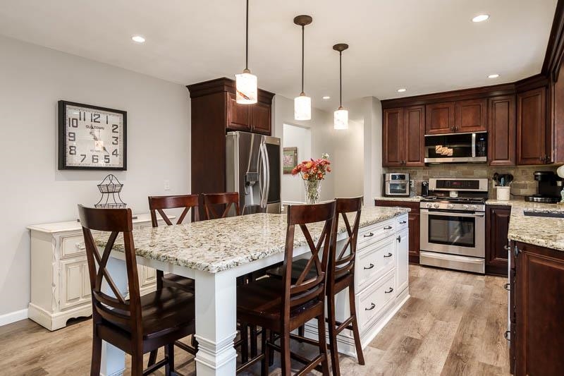 11948 Southgate Road Roscoe, IL 61073 - Photo 21 of 73 a kitchen with stainless steel appliances granite countertop a kitchen island a stove a table and chairs