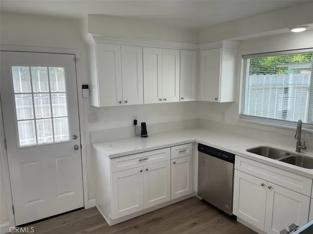 a kitchen with white cabinets window and sink