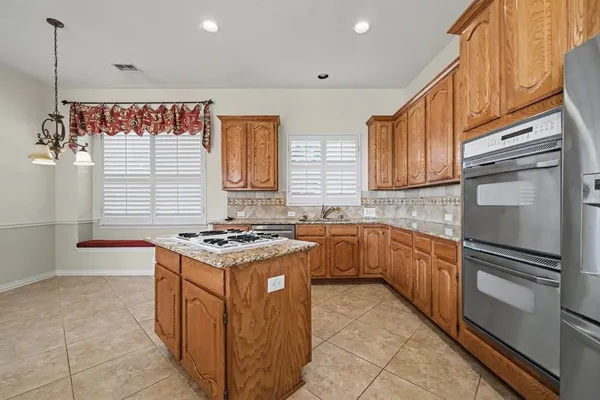 a kitchen with stainless steel appliances granite countertop a stove and a refrigerator
