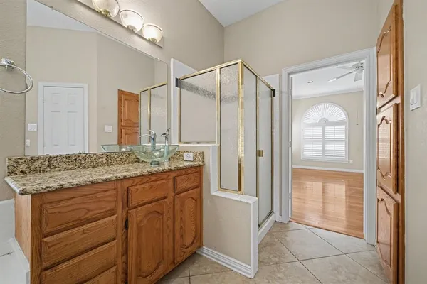 a bathroom with a granite countertop sink a mirror and a shower