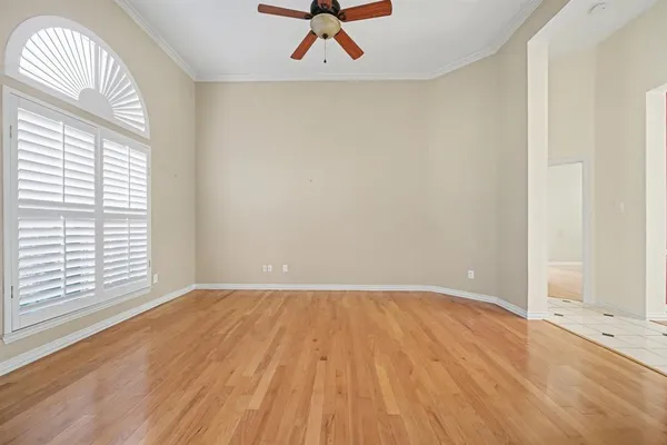 an empty room with a window and a ceiling fan
