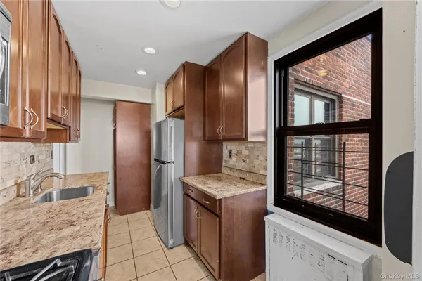 a kitchen with granite countertop a refrigerator stove and sink