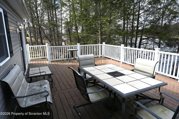 a roof deck with a table and chairs and wooden floor