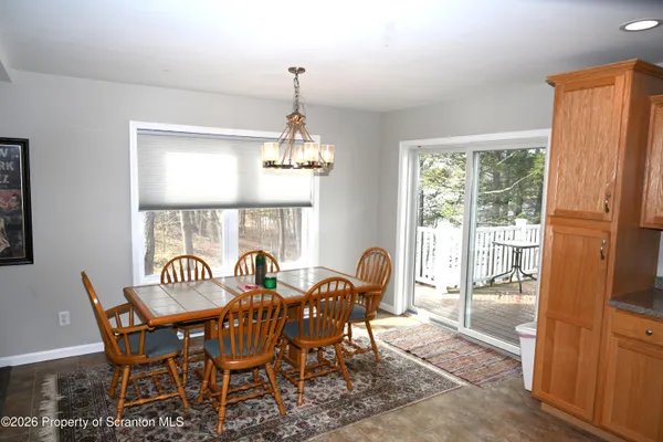 a view of a dining room with furniture a chandelier and wooden floor