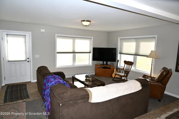 a living room with furniture a flat screen tv and a window