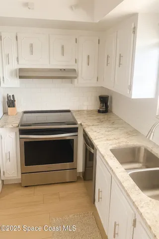 a bedroom with a bed and a flat tv screen on dresser