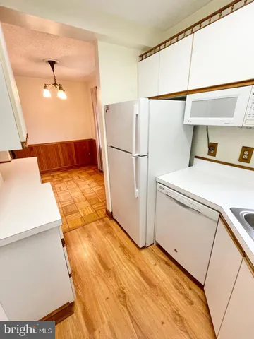 a kitchen with a refrigerator sink and cabinets