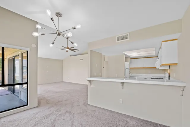 a view of a kitchen with a sink and chandelier
