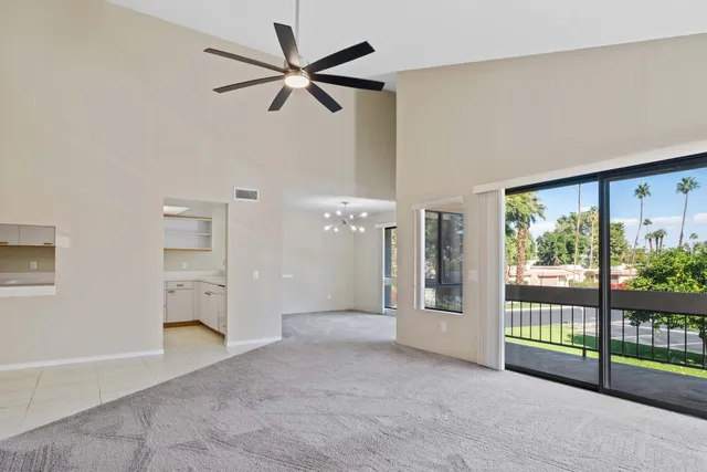 a view of a big room with windows and a ceiling fan