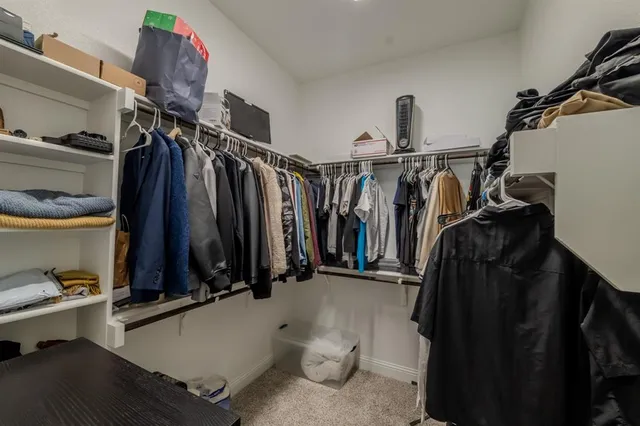 a view of walk in closet with clothes and shoes