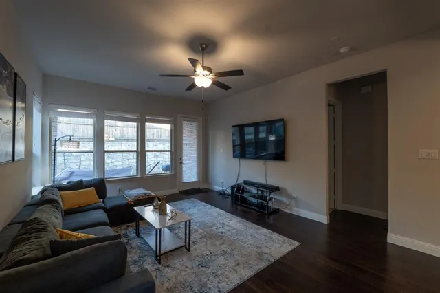 a living room with furniture a flat screen tv and a window