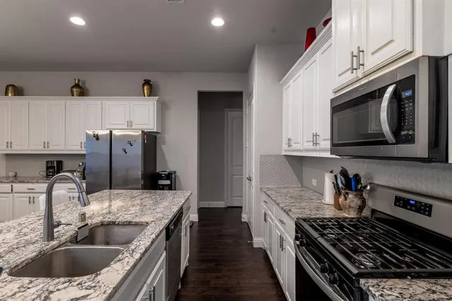 a kitchen with stainless steel appliances granite countertop a sink stove and refrigerator