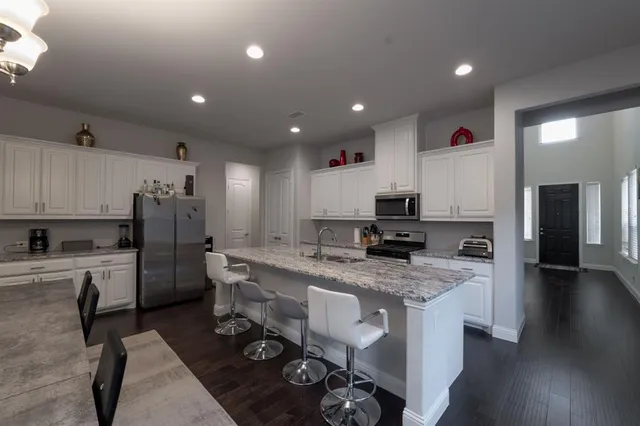 a kitchen with stainless steel appliances granite countertop a sink refrigerator and microwave